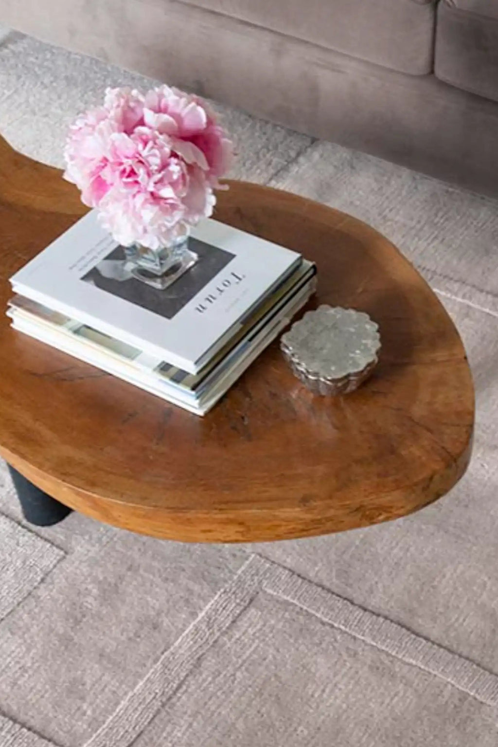 Layered Swedish Grace Wool Rug, a light gray, textured wool area rug with subtle geometric patterns and stitched details, complementing a natural wood coffee table. Perfect for adding Scandinavian...