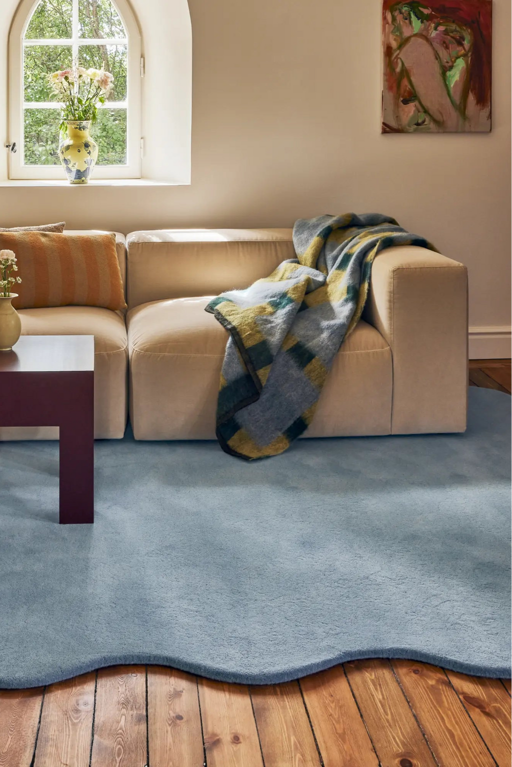 Layered Scallop Wool Rug, a light blue hand-tufted wool area rug with a unique wavy, scalloped edge design. Perfect for adding a soft, modern touch to living room decor.