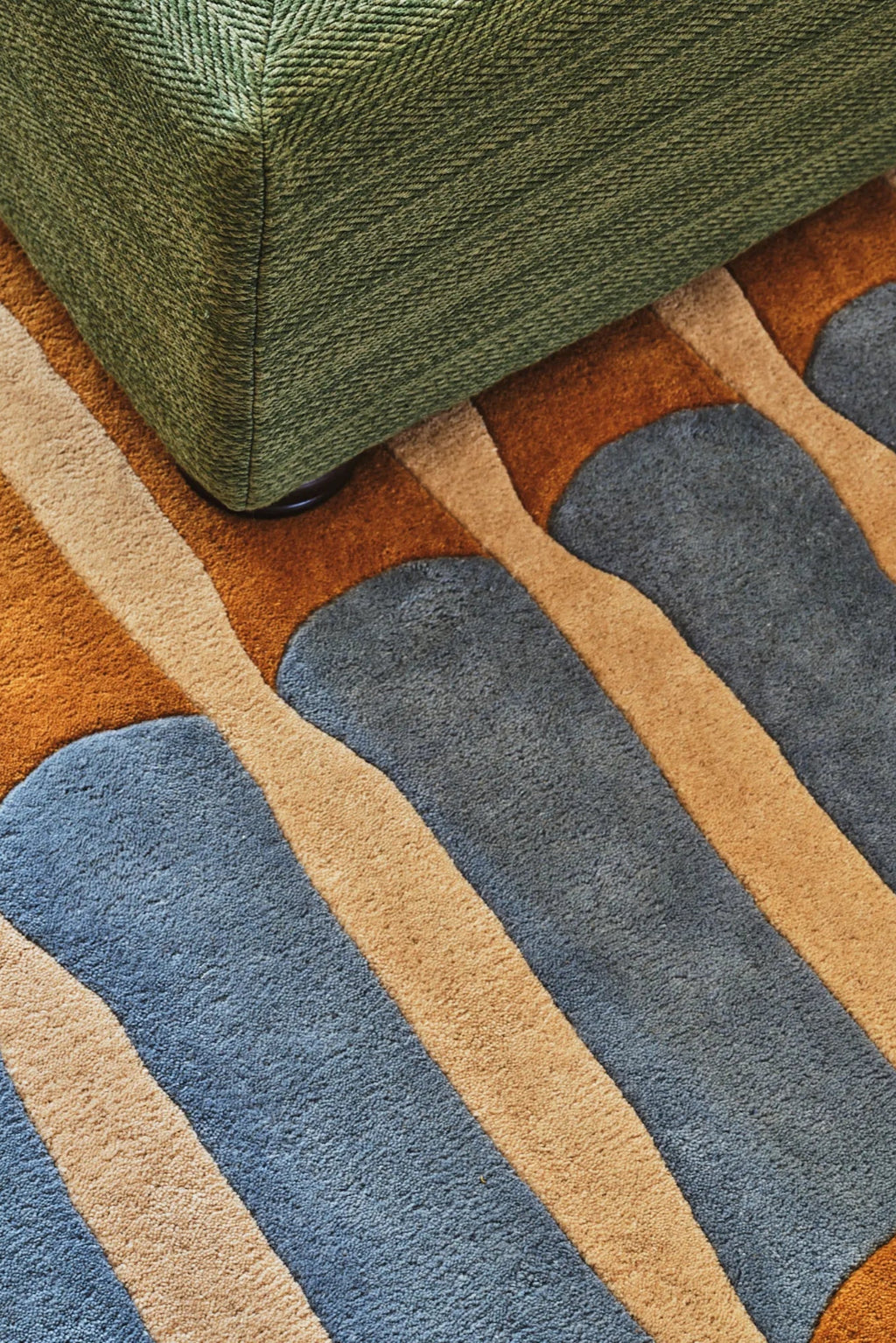 Layered Bamboo Forest Wool Rug, a luxurious modern area rug featuring abstract, organic shapes in earthy tones of rust, sky blue, and beige. Perfect for adding a natural, artistic touch to any livi...