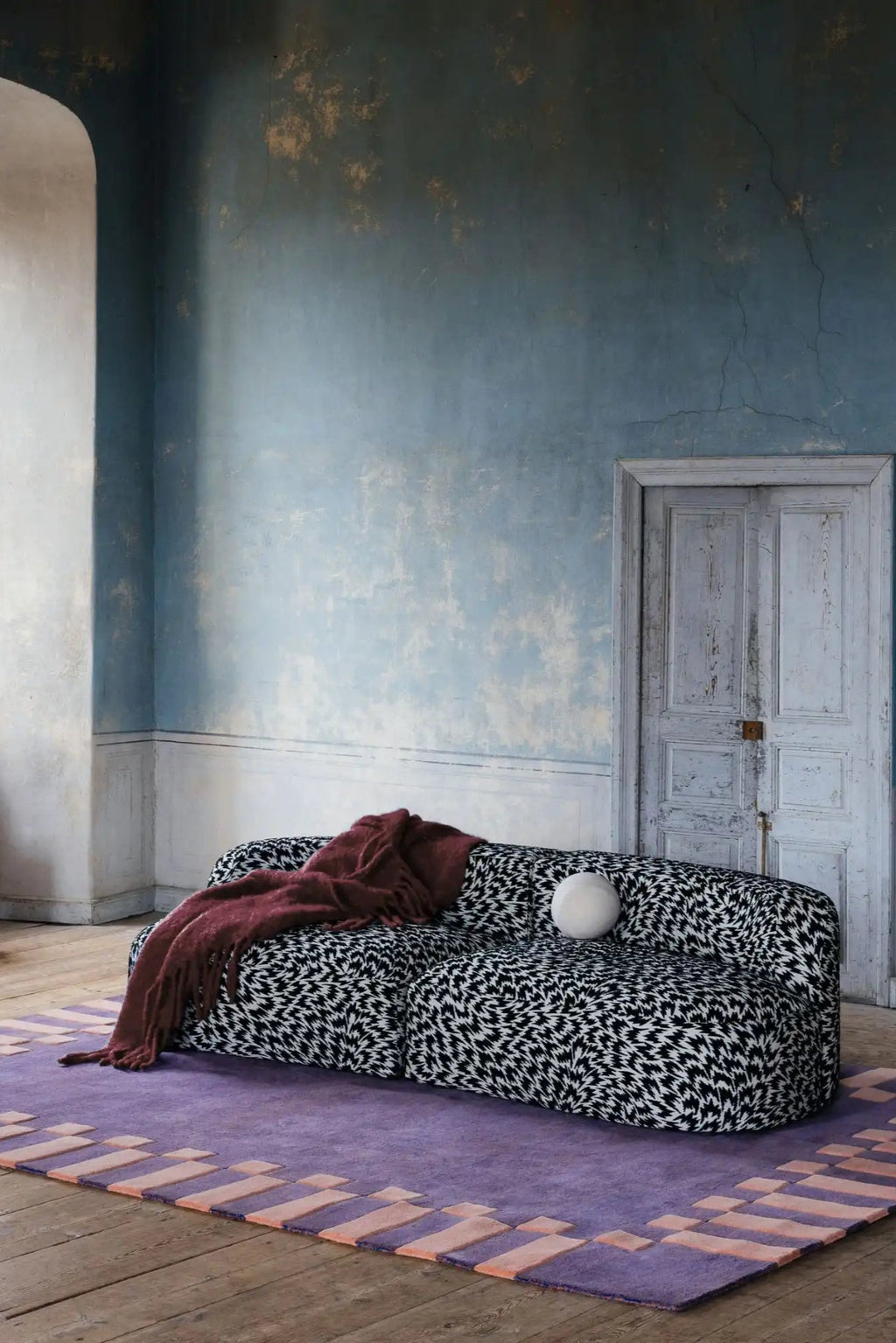 Layered Frame Wool Rug, a vibrant purple area rug with a unique peach geometric border design. Perfect for adding a modern, artistic touch to living room decor or bedroom flooring.
