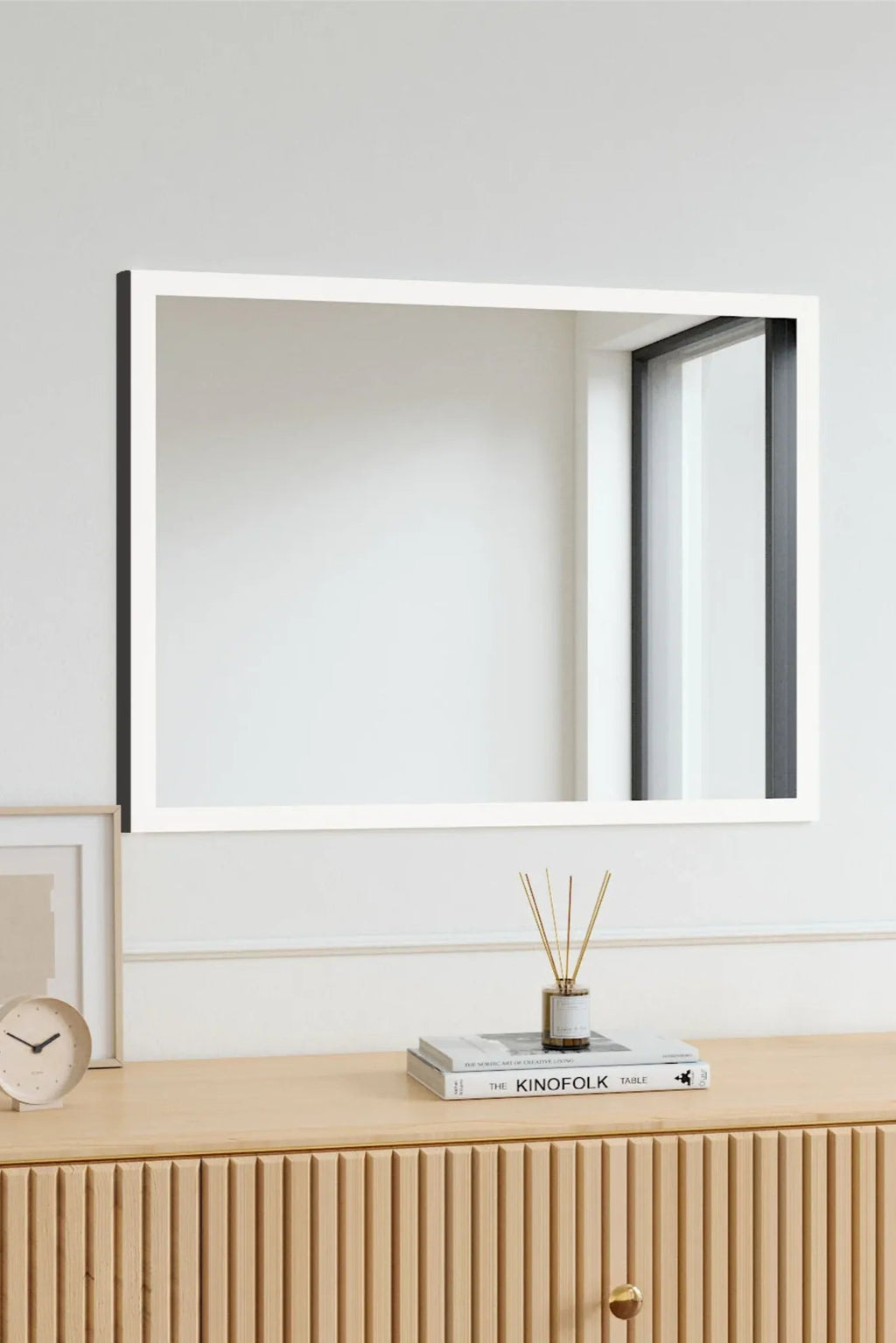TCL Studios Full Lux Mirror With LED Lights, a sleek rectangular LED wall mirror featuring a crisp white frame with a contrasting matte black side profile, offering a modern minimalist design. This contemporary mirror includes integrated LED lighting for optimal illumination and a sophisticated aesthetic. Ideal as a stylish bathroom vanity mirror, a bright bedroom accent, or a clean entryway mirror for modern homes.