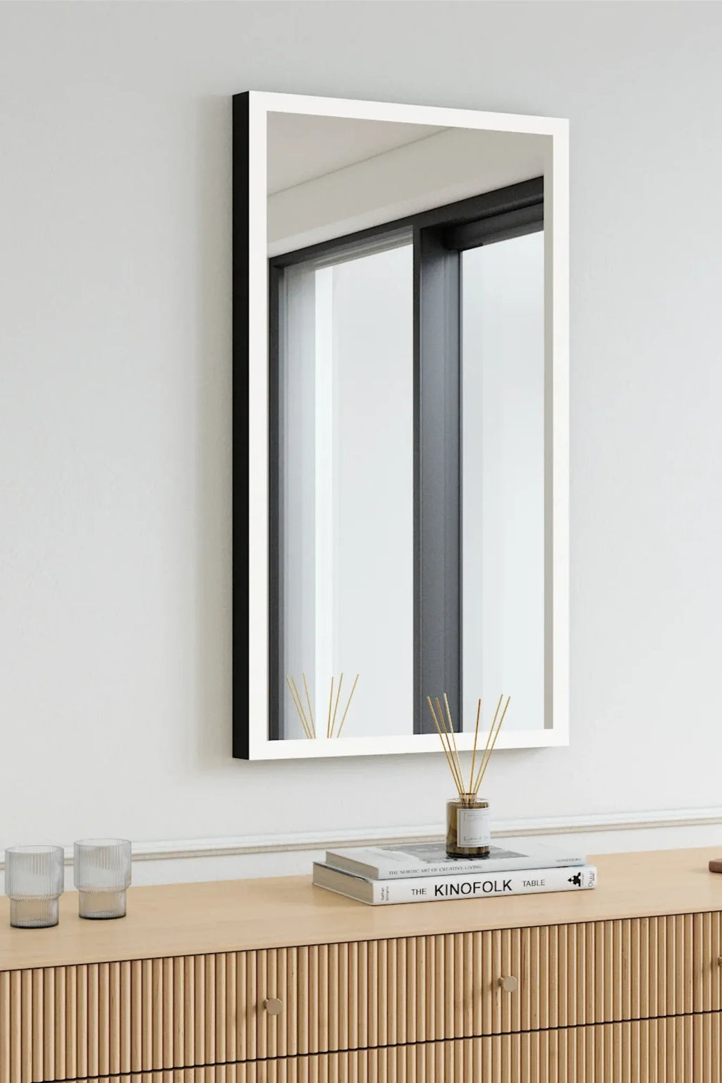 TCL Studios Full Lux Mirror With LED Lights, a sleek modern rectangular wall mirror featuring a crisp white front frame and a contrasting matte black side profile, with integrated LED lighting for optimal illumination. This contemporary LED mirror is perfect as a minimalist vanity mirror, bedroom accent, or stylish entryway mirror in modern and Scandinavian interiors.