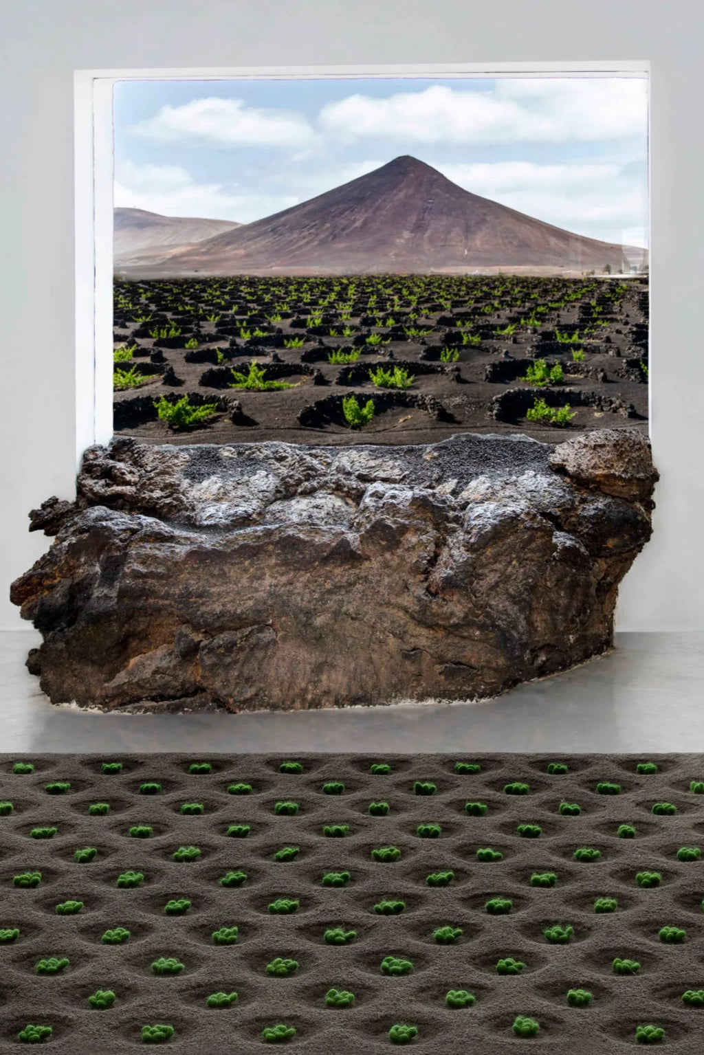 GAN Rugs La Geria-Lanzarote Rug, a striking hand-tufted wool area rug featuring a deep charcoal grey textured base that mimics volcanic soil, intricately designed with vibrant green felted.