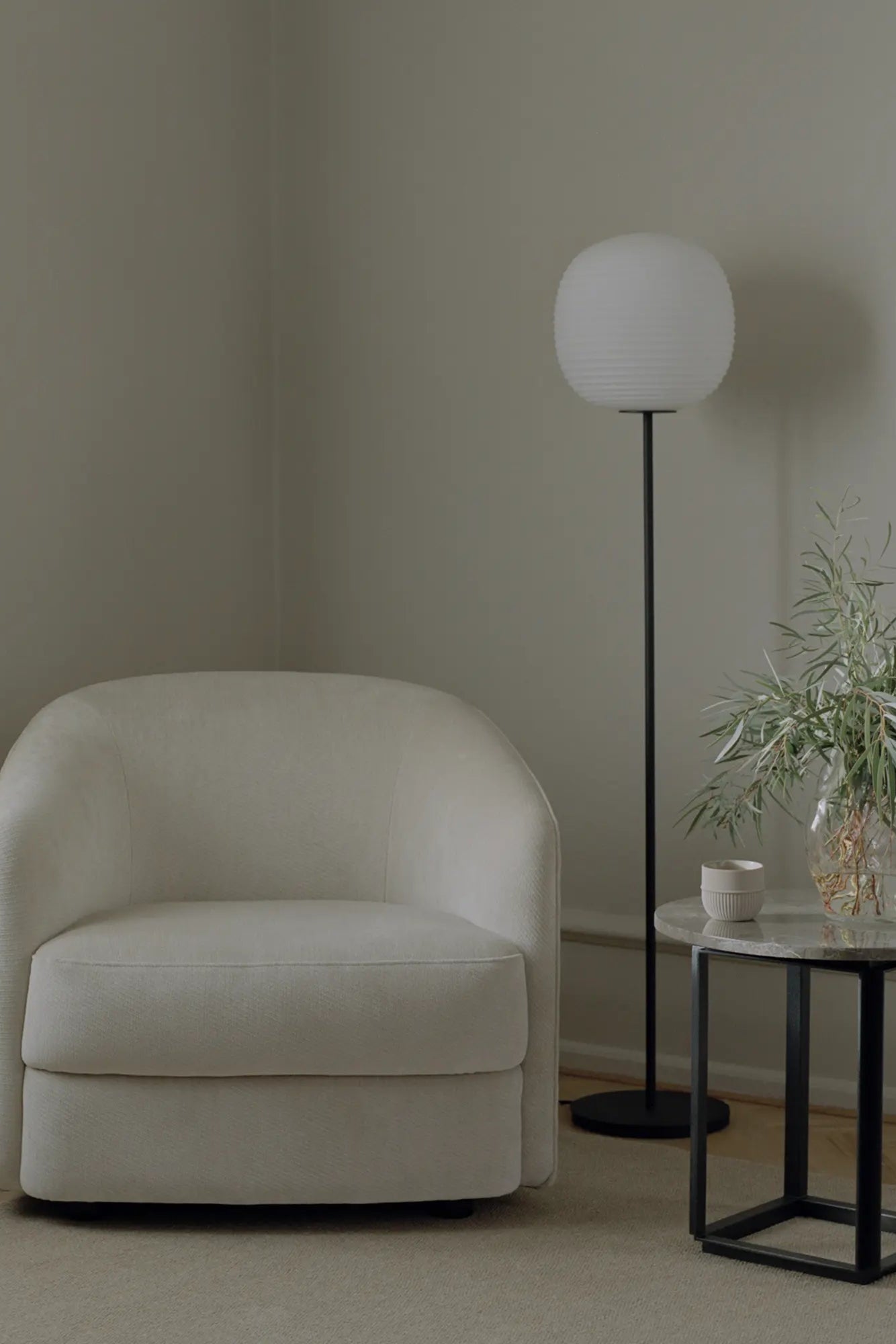 Elegant lantern floor lamp with a bronze finish illuminating a cozy reading nook