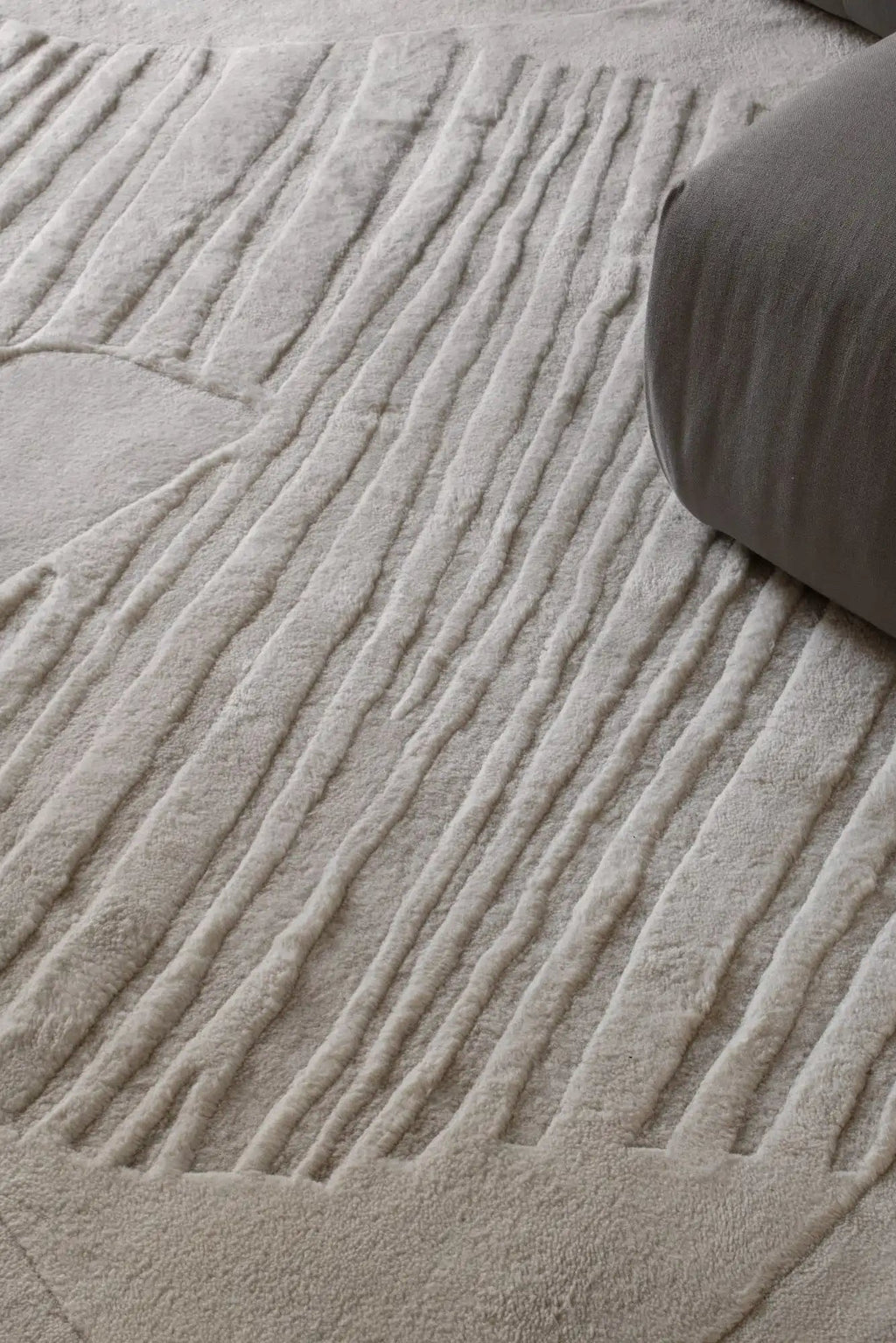 Layered Artisan Guild Wool Rug, a luxurious cream-colored wool rug with a textured, raised stripe pattern and plush pile. Perfect for adding warmth and sophisticated style to any living room or bed...