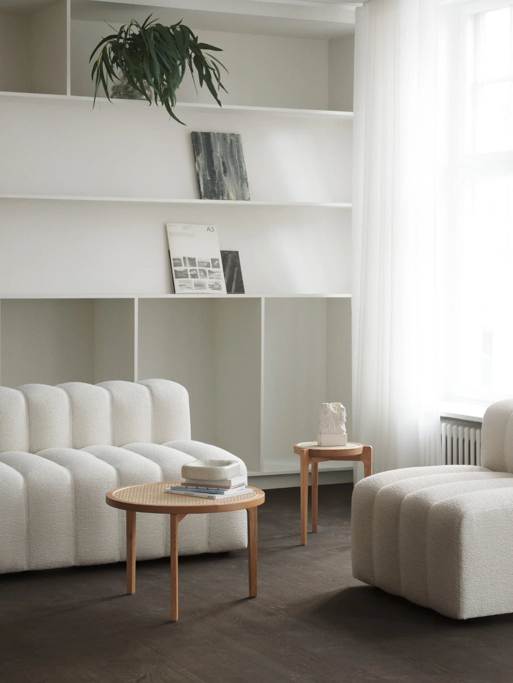 NORR11 Le Roi Side Table, a round light oak wood table with a distinctive cane woven top, styled next to a modern white sofa. This premium, authentic wood side table is ideal for contemporary living spaces.