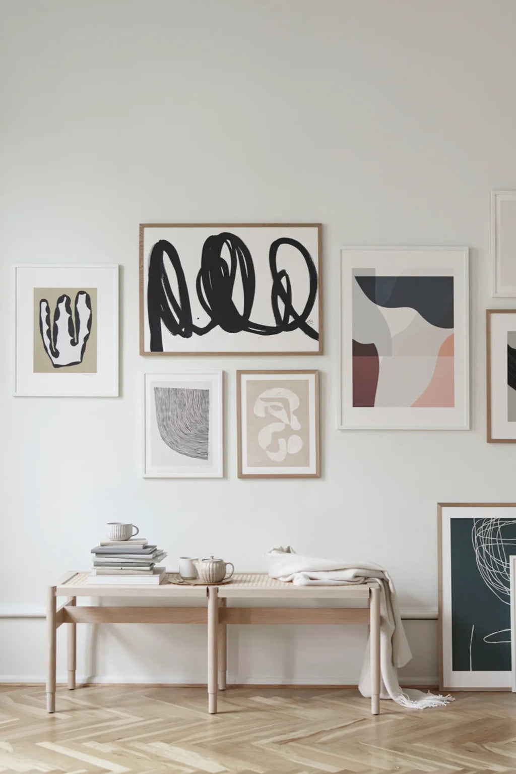 The Poster Club Curves, a large modern minimalist abstract art print featuring bold black looping brushstroke-like lines on a crisp white background, framed in light natural oak. This contemporary black and white poster is perfect for creating a focal point in a gallery wall, living room, or bedroom.