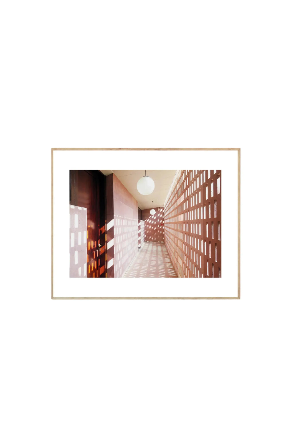 The Poster Club Lights - Art Print, featuring a modern architectural hallway with warm terracotta-colored perforated walls casting intricate light and shadow patterns on the floor, framed in light natural wood. This stylish poster is perfect for contemporary art lovers and interior design enthusiasts looking to add unique visual interest to their space.