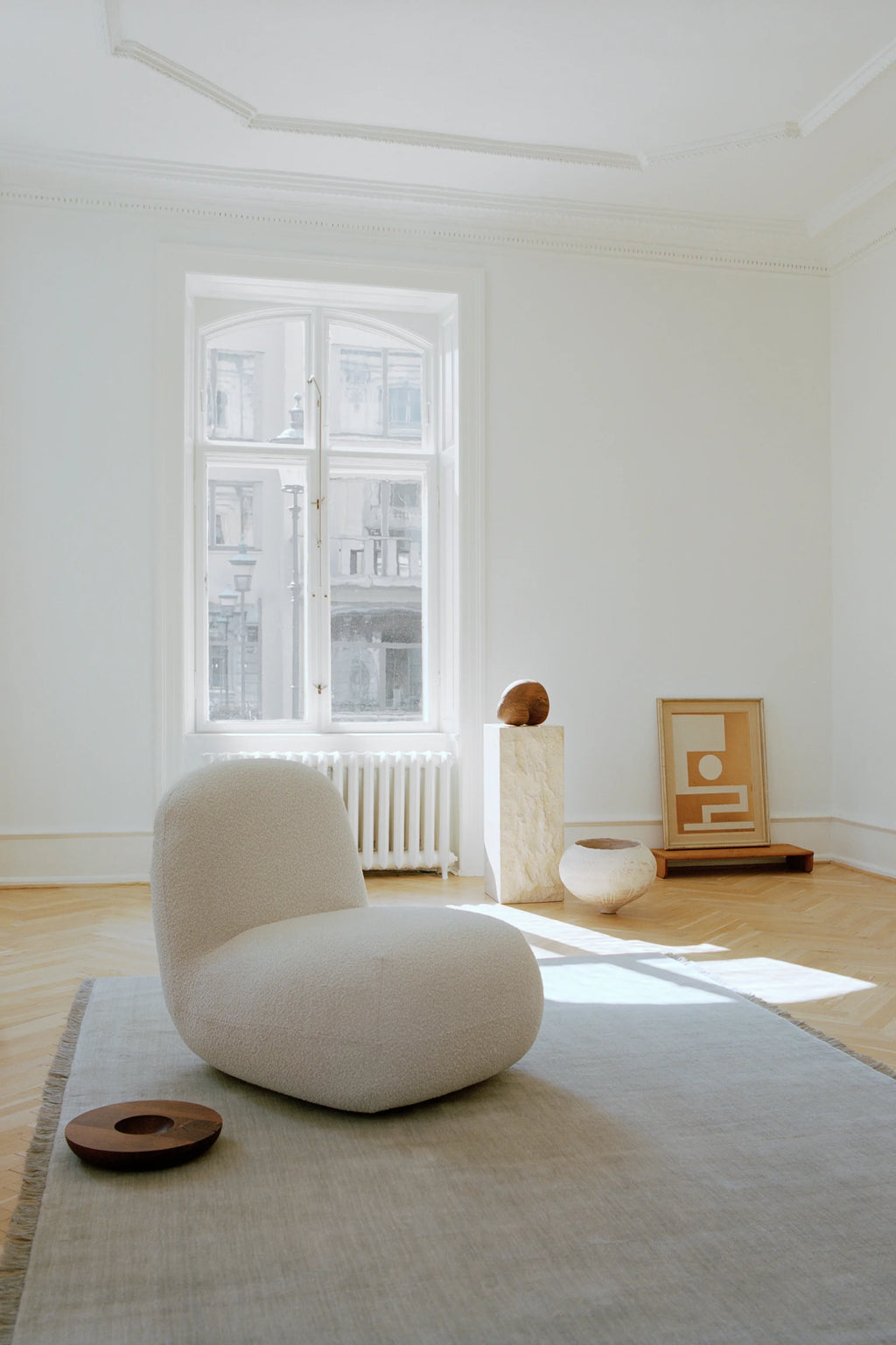 Linie Design Abyss Bliss Wool Rug, a hand-woven wool area rug in a soft, natural light grey tone with subtle textural variations and delicate fringed edges, showcasing a minimalist flat weave design. This versatile, neutral rug is perfect for Scandinavian living rooms, organic modern bedrooms, or contemporary minimalist spaces.