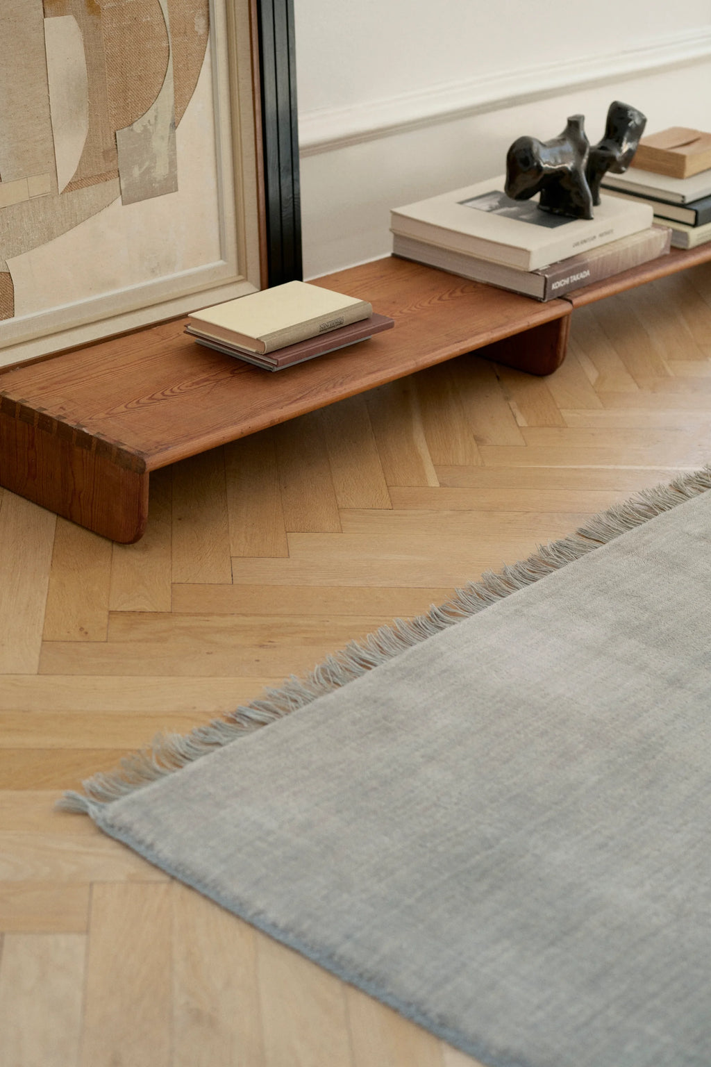 Linie Design Abyss Bliss Wool Rug, a soft light grey wool area rug featuring a subtle textured weave and delicate fringed edges, offering a minimalist yet cozy aesthetic. This Scandinavian-inspired rug is perfect for adding warmth and understated elegance to modern living rooms, bedrooms, or serene reading nooks.