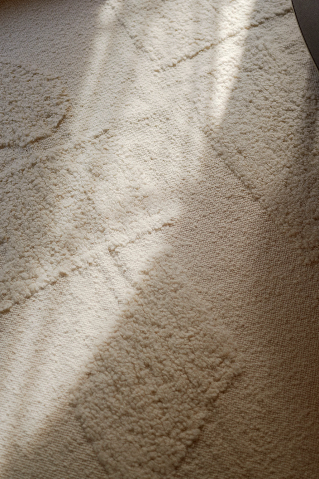 Linie Design Polar Angels Wool Rug, a plush hand-knotted wool area rug in creamy off-white and natural ivory tones, featuring a distinctive high-low textured weave that forms a subtle geometric pattern. This Scandinavian-inspired rug is perfect for adding warmth and organic texture to modern minimalist living rooms, bedrooms, or cozy spaces.