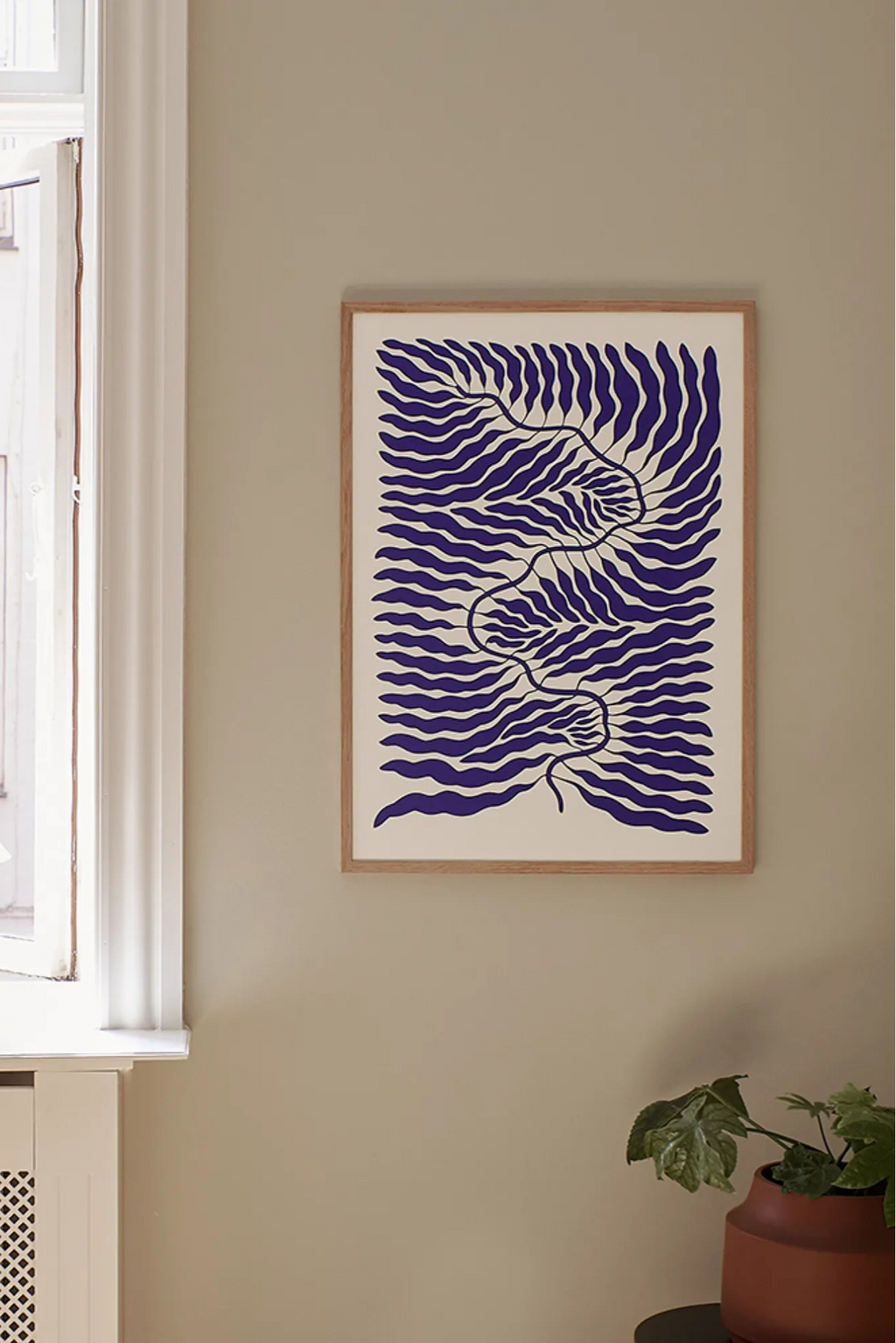 The Poster Club Little Blue, an abstract art print showcasing dynamic, wavy indigo blue organic forms against a warm off-white background. This contemporary poster is presented in a sleek natural oak wood frame, highlighting its minimalist design. Ideal for modern minimalist living rooms, Scandinavian bedrooms, or as a striking piece in a curated gallery wall.