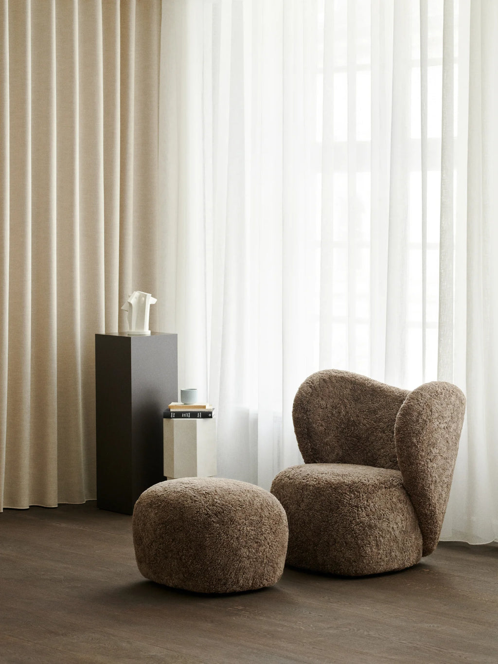 NORR11 Little Big Pouf, a round, plush pouf in a rich chocolate brown textured boucle fabric. This elegant and cozy pouf offers premium comfort and stylish versatility. It's perfect for adding a touch of luxury and functional seating to any modern living space.