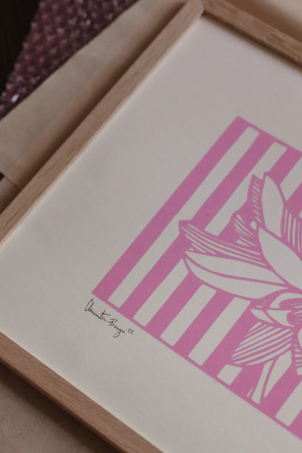 The Poster Club Lotus No 01, a contemporary graphic art print featuring a stylized white lotus flower with intricate details set against a bold fuchsia pink and white striped background, signed by the.