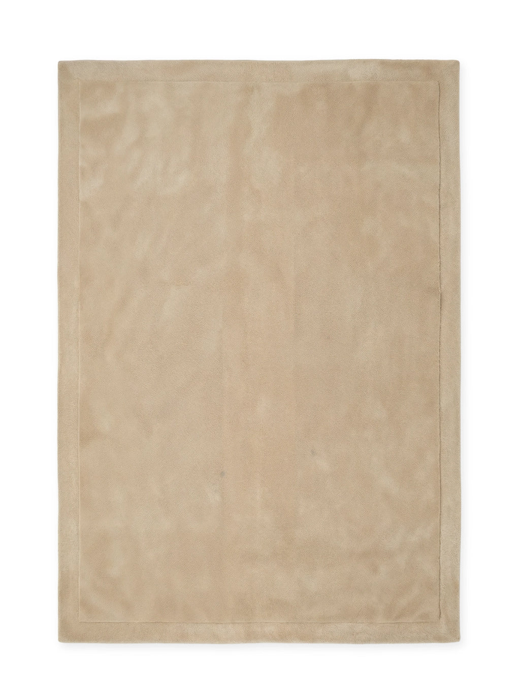 Tinted Objects Louis Wool Rug, a rectangular, solid beige-oatmeal colored rug with a subtle textured border. This luxurious and versatile wool rug is perfect for adding warmth and sophisticated style to any modern living room or bedroom.