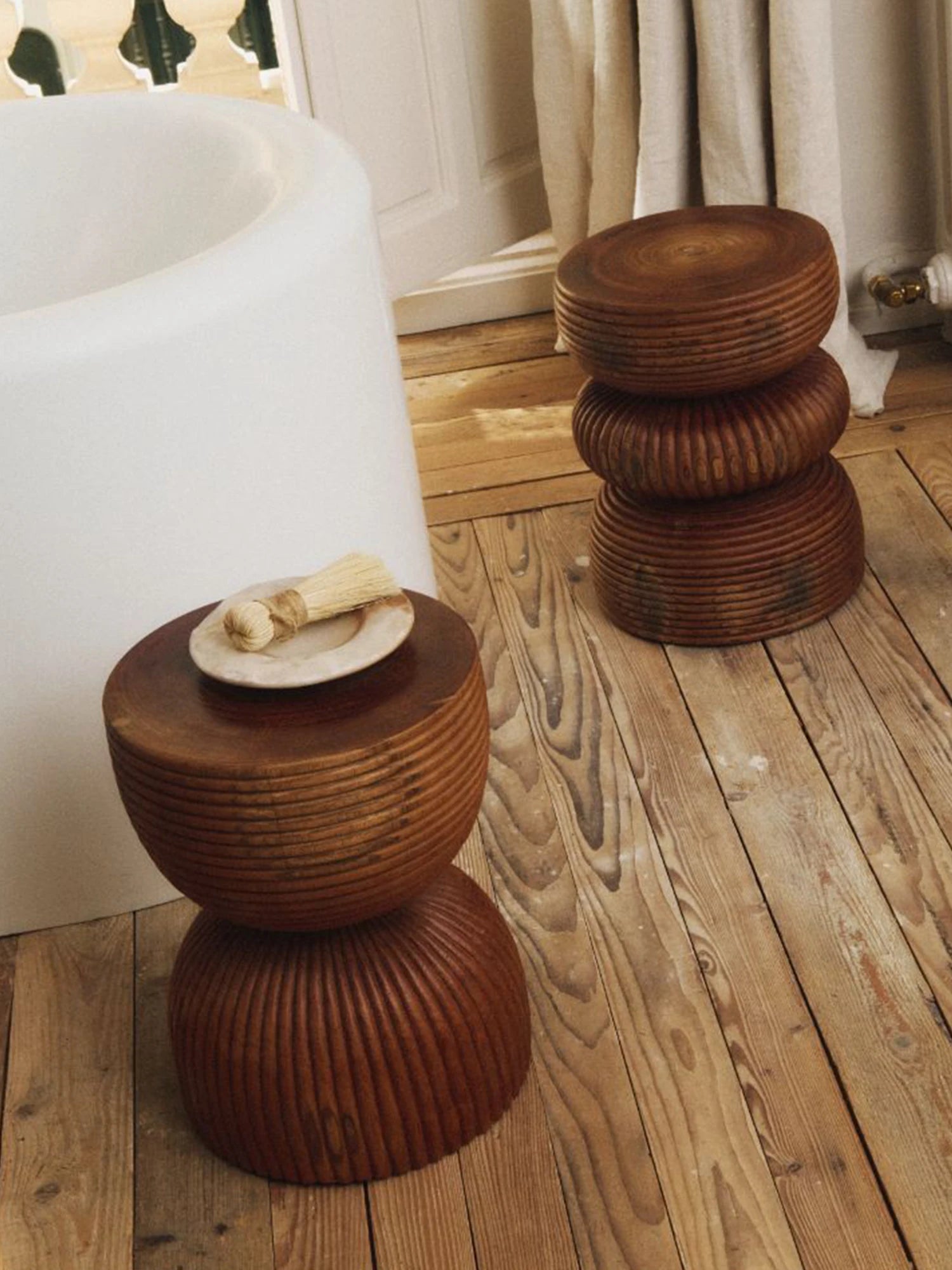 Heaps & Woods Luka Stool, a sculptural organic modern stool crafted from rich reddish-brown solid wood, featuring stacked, rounded forms with deeply grooved, turned wood textures creating a distinct, handcrafted silhouette. Ideal as a unique side table, accent stool, or bedside table in natural modern, rustic, or wabi-sabi inspired living spaces and bathrooms.