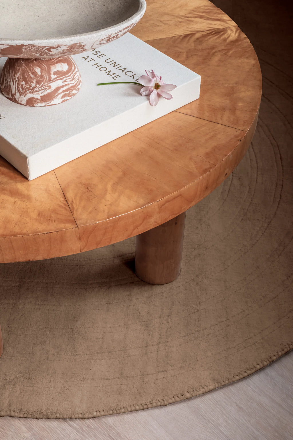 Layered Circular Wool Rug, a plush beige circular area rug with subtle concentric line patterns, made from soft, natural wool fibers. Perfect for adding warmth and texture to any modern living room...