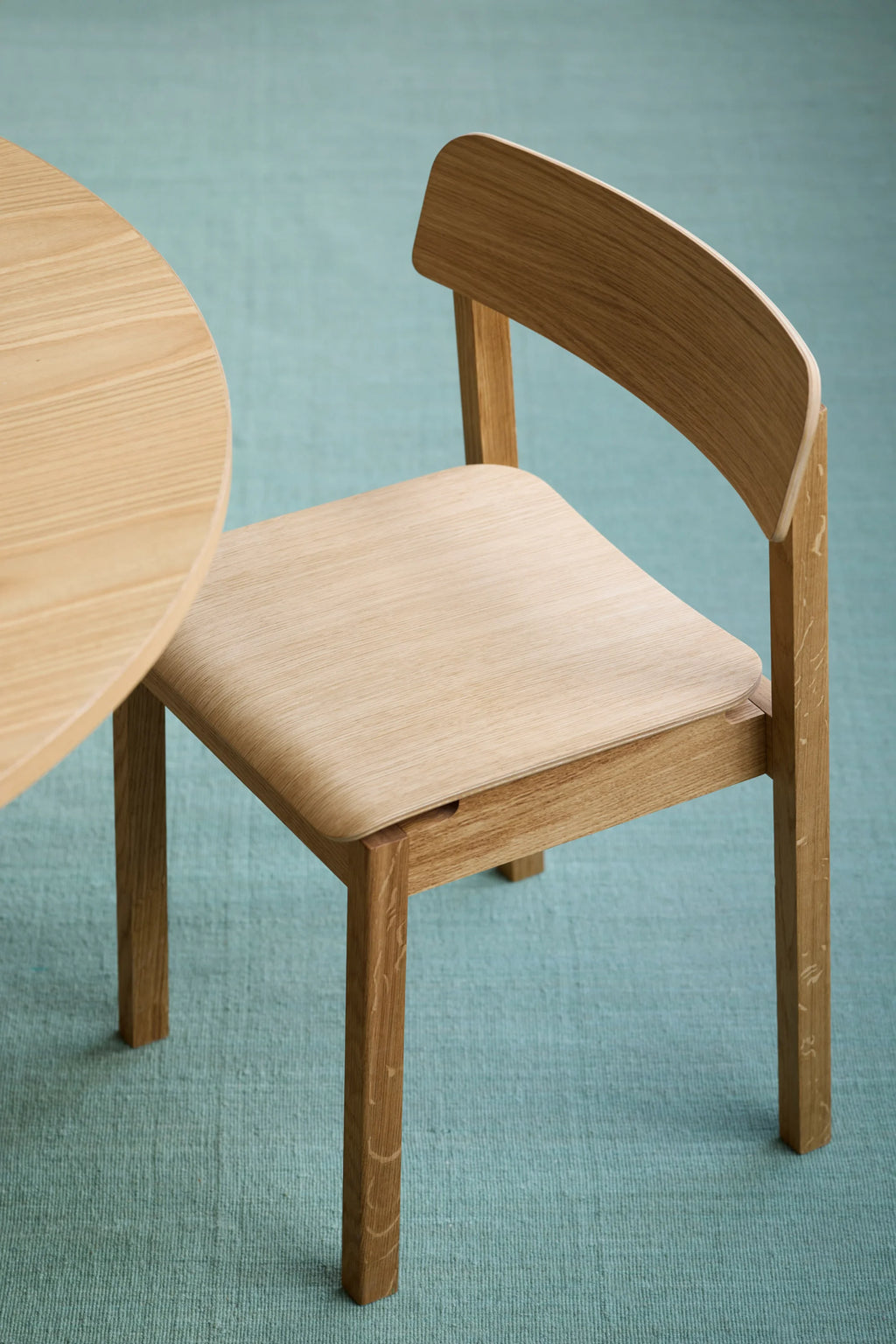 MOEBE Everyday Chair, a modern minimalist dining chair crafted from light natural solid oak wood, featuring a gently curved bent plywood backrest and seat. Its clean Scandinavian design showcases visible wood grain and smooth, rounded edges, providing a contemporary aesthetic. Ideal as a versatile dining chair or stylish accent chair for modern kitchens, dining rooms, or home offices.