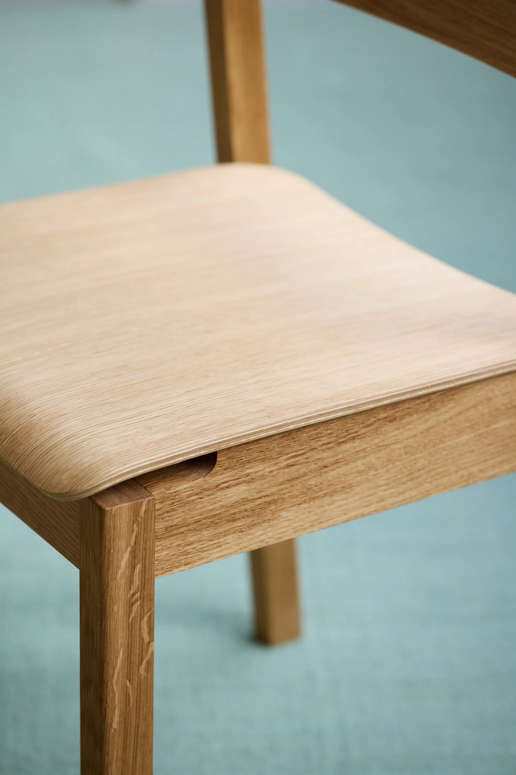 MOEBE Everyday Chair, a modern minimalist dining chair crafted from light natural solid oak wood with a gently curved bent plywood seat in complementary blonde wood tones. This Scandinavian-inspired wooden chair features clean lines and visible wood grain, showcasing its contemporary design. Ideal as a versatile dining chair or stylish accent chair for modern living spaces and home offices.