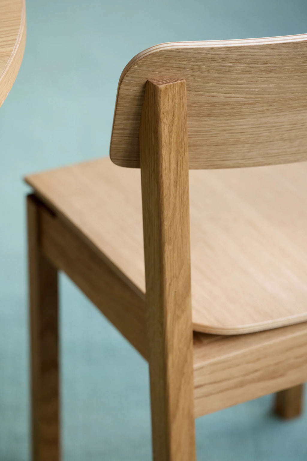 MOEBE Everyday Chair, a modern minimalist dining chair crafted with a solid natural oak wood frame and ergonomic curved seat and backrest made from light oak veneer plywood, showcasing a warm, visible wood grain. Its clean Scandinavian design and simple, elegant form make it a perfect versatile wooden chair for contemporary dining rooms, modern kitchens, or a stylish home office desk.