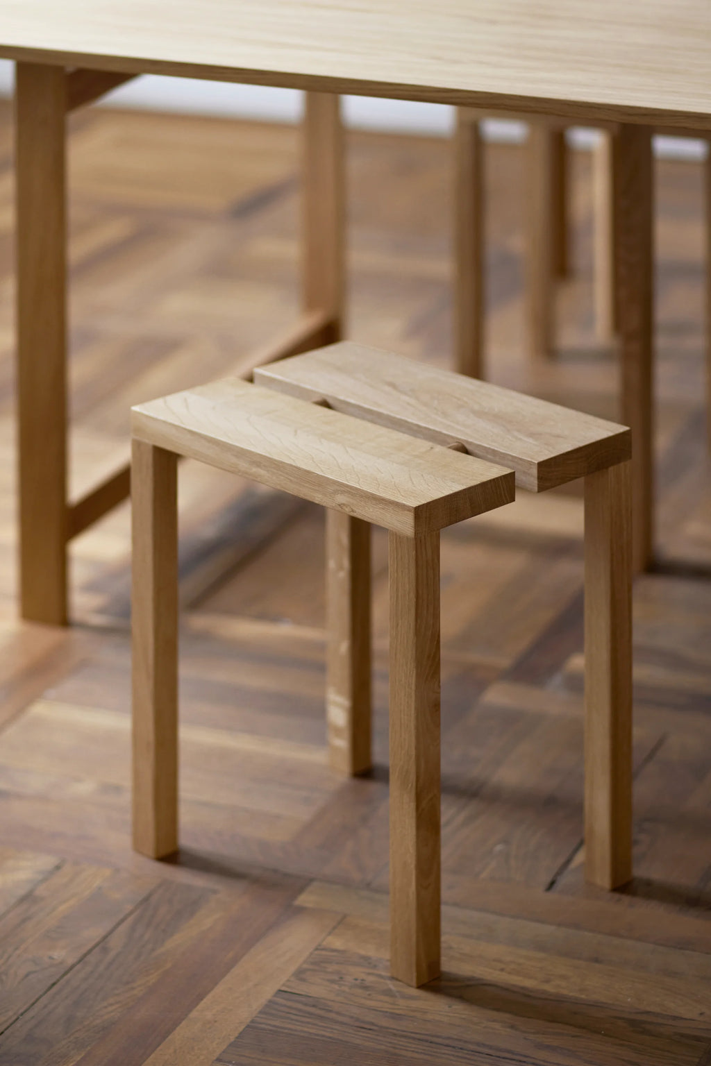 MOEBE Peg Stool, a minimalist solid oak stool with a light natural wood finish, featuring two distinct rectangular seat planks and clean, straight legs. This Scandinavian-inspired wooden stool offers a versatile design, perfect as an accent stool for modern minimalist interiors, a small side table, or a unique plant stand.