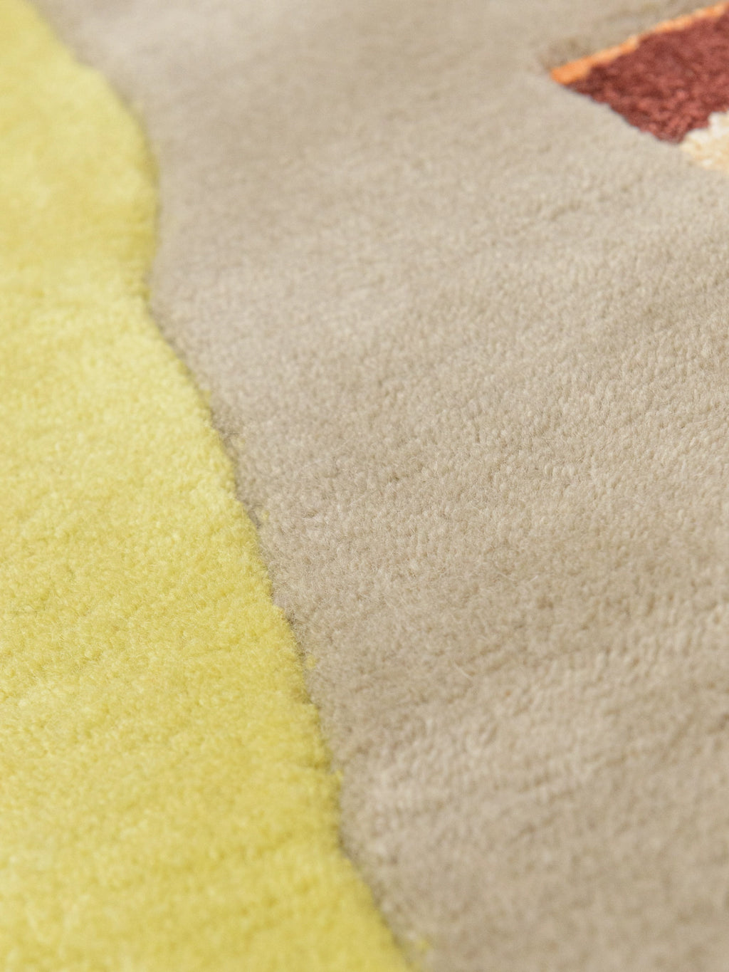 Haus Üger Moth Rug, a plush hand-tufted wool area rug featuring a soft, textured pile in warm beige and sand tones, accented with vibrant lime green, terracotta, and deep brown organic abstract shapes.
