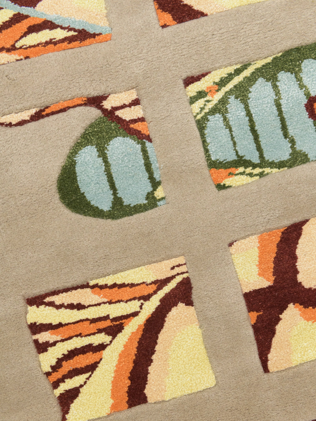 Haus Üger Moth Rug, a plush contemporary area rug featuring abstract, nature-inspired segmented patterns resembling colorful moth wings on a soft beige background. This vibrant wool rug showcases a rich palette of light blue, dark green, sunny yellow, warm orange, and deep brown, creating a textured, artistic design with varying pile heights. An eye-catching focal point, perfect for modern living rooms, creative bedrooms, or unique contemporary interior designs.