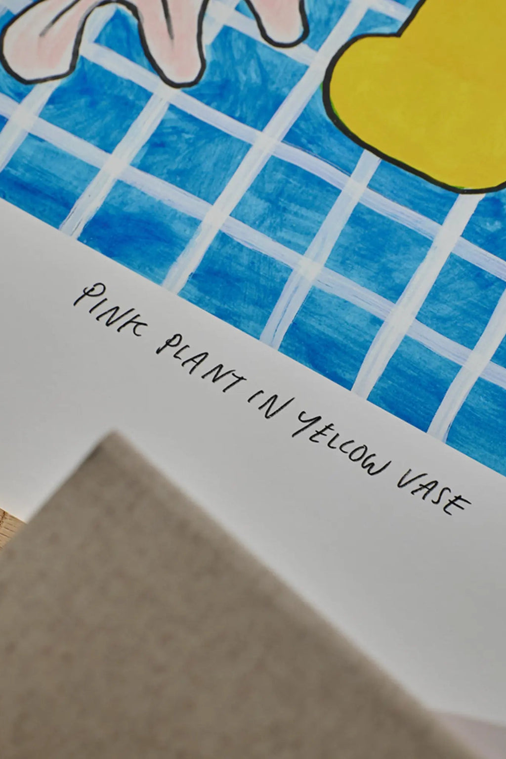 The Poster Club Pink Plant in Yellow Vase, a vibrant and playful modern art print featuring an abstract pink plant illustration in a bold yellow vase, set against a bright blue hand-painted grid background with visible brushstrokes. This colorful graphic poster is ideal for adding a contemporary touch to living room walls, bedroom decor, or creative studio spaces.