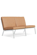 Modern two-seater sofa with tan leather seats and white metal frame on a white background