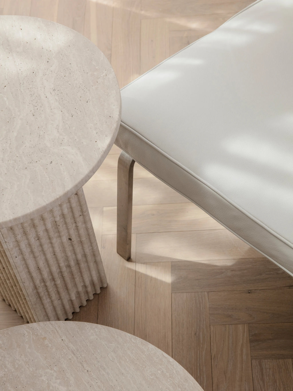 NORR11 Man 2 Seater Sofa, a modern minimalist lounge sofa featuring soft light cream upholstery with elegant piping details, supported by a natural light wood frame with gently curved legs.