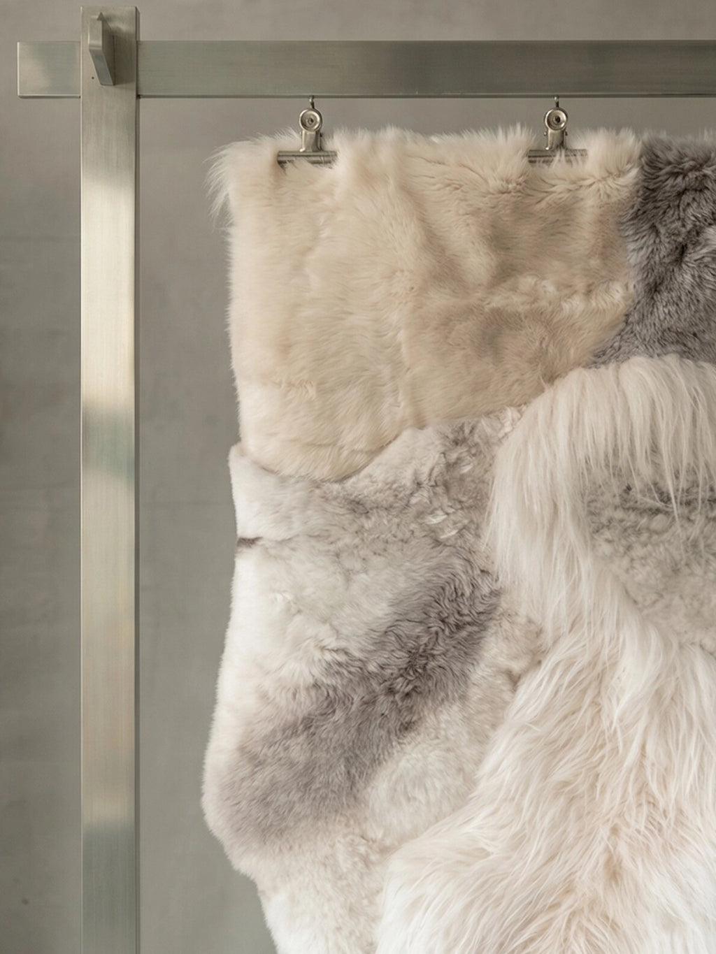 TCL Studios Melange Sheepskin Patchwork Rug, a luxurious and cozy multi-tone sheepskin rug featuring a patchwork design of varying natural sheepskin textures and colors, including soft cream, off-white, and light grey hues. This plush, shaggy real sheepskin area rug brings organic modern style and warmth to Scandinavian bedrooms, living rooms, or nurseries.
