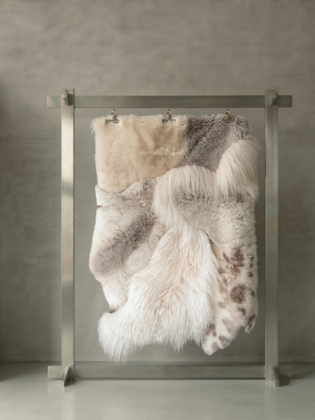 TCL Studios Melange Sheepskin Patchwork Rug, a luxurious natural sheepskin rug crafted from a blend of cream, white, and light grey sheepskin patches with varying pile lengths and natural spotted patterns, creating a plush, shaggy texture. This multi-tone sheepskin rug offers an organic modern aesthetic, perfect as a cozy area rug for a Scandinavian living room, warm bedroom accent, or rustic chic interior.