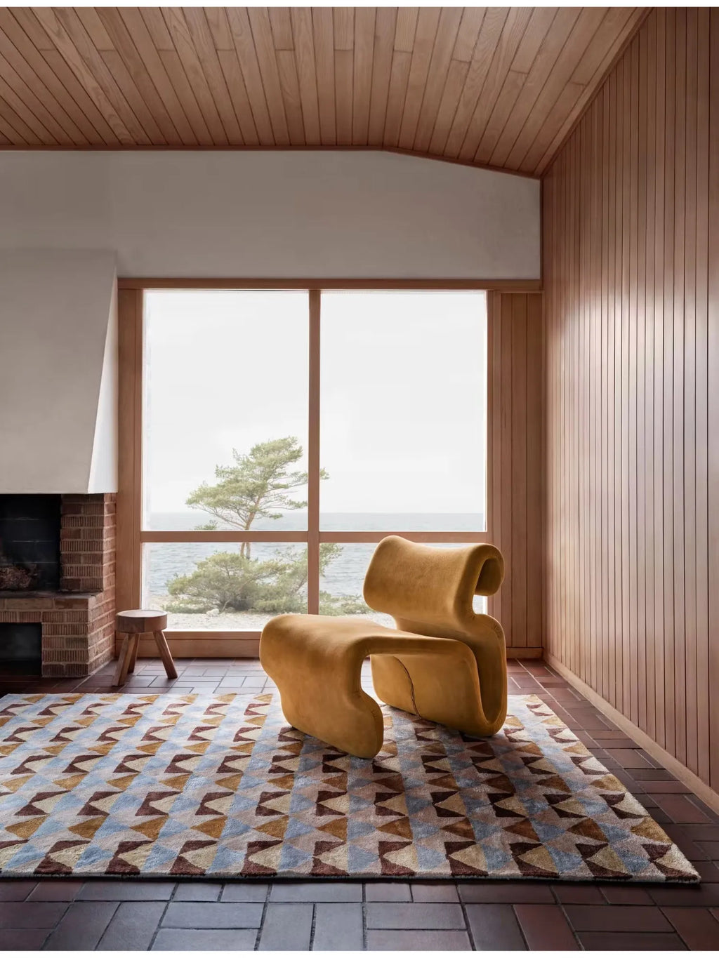 Tinted Objects Mellin Viscose Rug, featuring a modern geometric triangular pattern in shades of light blue, brown, and gold. This stylish area rug is perfect for adding contemporary flair and warmth to a living room or bedroom for design-conscious homeowners.