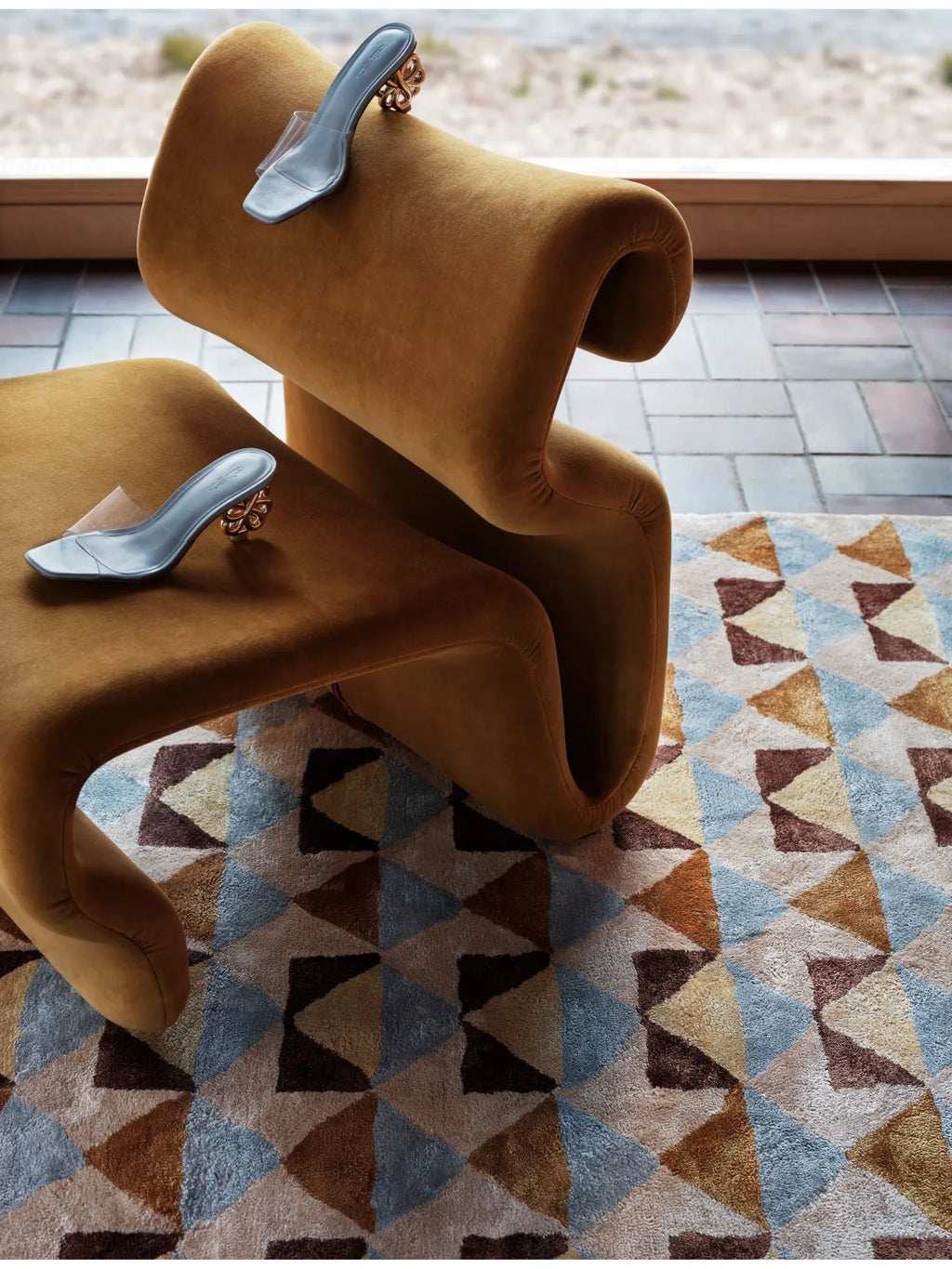 Tinted Objects Mellin Viscose Rug, featuring a modern geometric pattern of triangles in shades of light blue, brown, beige, and golden yellow with a plush, soft texture. This stylish area rug is perfect for adding contemporary flair and warmth to any living room or bedroom.