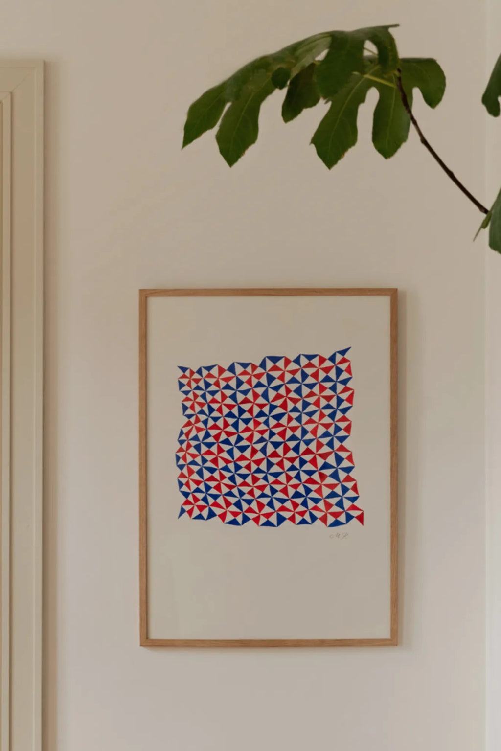 The Poster Club Tern No. 3, a striking geometric abstract art print featuring a vibrant red and blue triangular pattern arranged in a dynamic, irregular shape against a clean white background, housed in a sleek natural oak frame. Perfect as modern wall art for contemporary gallery walls or minimalist home decor.