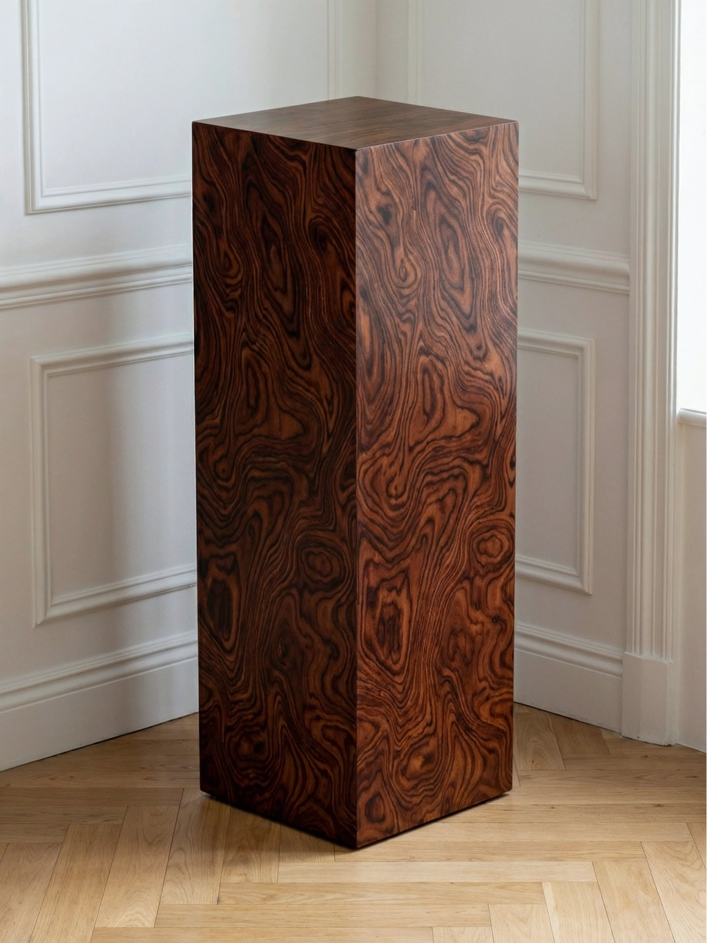 TCL Studios Monolith Muscato Display Column, a striking contemporary minimalist pedestal crafted from rich dark figured wood veneer with an intricate, swirling grain pattern in deep reddish-brown and black tones. This tall, square display column features a polished, smooth finish and clean architectural lines. Ideal as a sculptural accent table for modern living rooms, elegant entryways, or sophisticated gallery spaces.