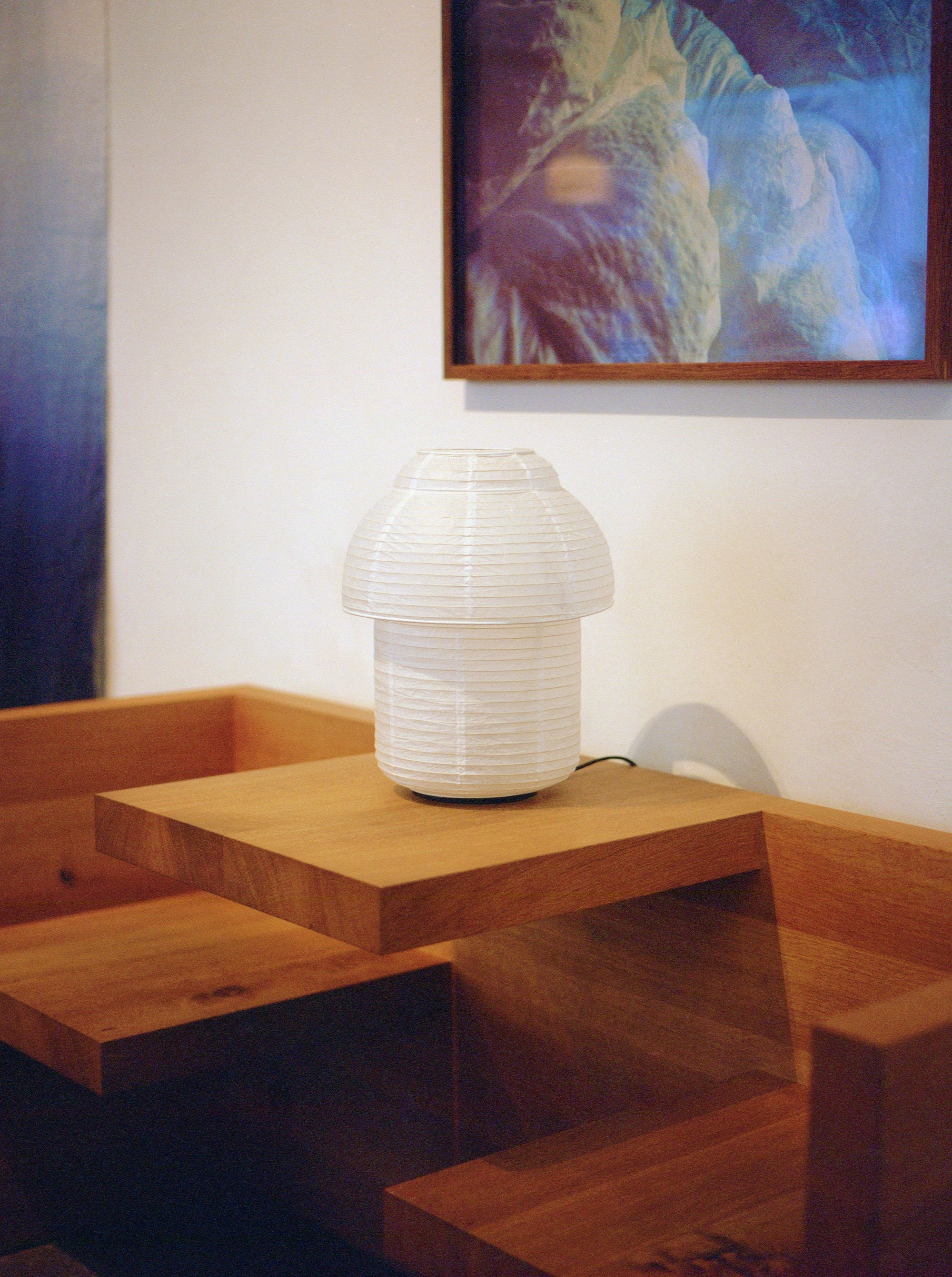 Made by Hand Papier Double Ø30 Table Lamp, a cream-colored organic modern table lamp featuring a distinctive mushroom-shaped shade crafted from pleated natural paper, creating a soft, diffused glow. This minimalist paper lantern lamp, with its tiered design and Japandi aesthetic, is ideal as a Scandinavian bedside lamp or a contemporary living room accent.