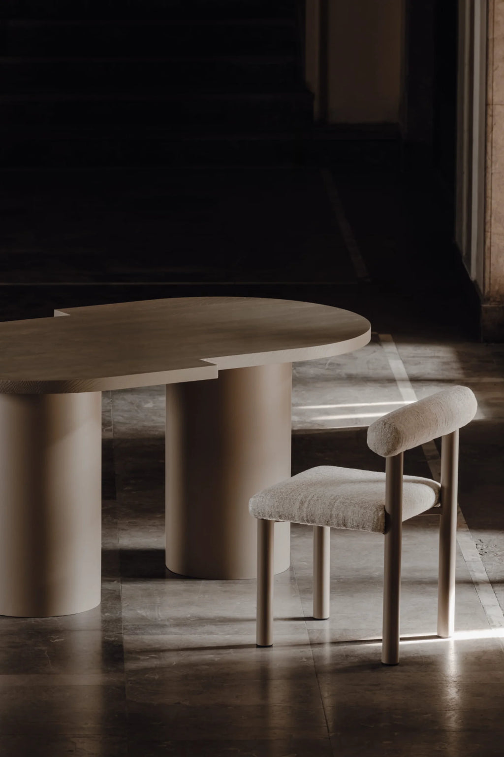 NG DESIGN Object 098 Dining Table, featuring a light beige wood elliptical top with two round pedestal bases, paired with a matching upholstered chair, showcasing luxury minimalist furniture design. Ideal for modern dining spaces.