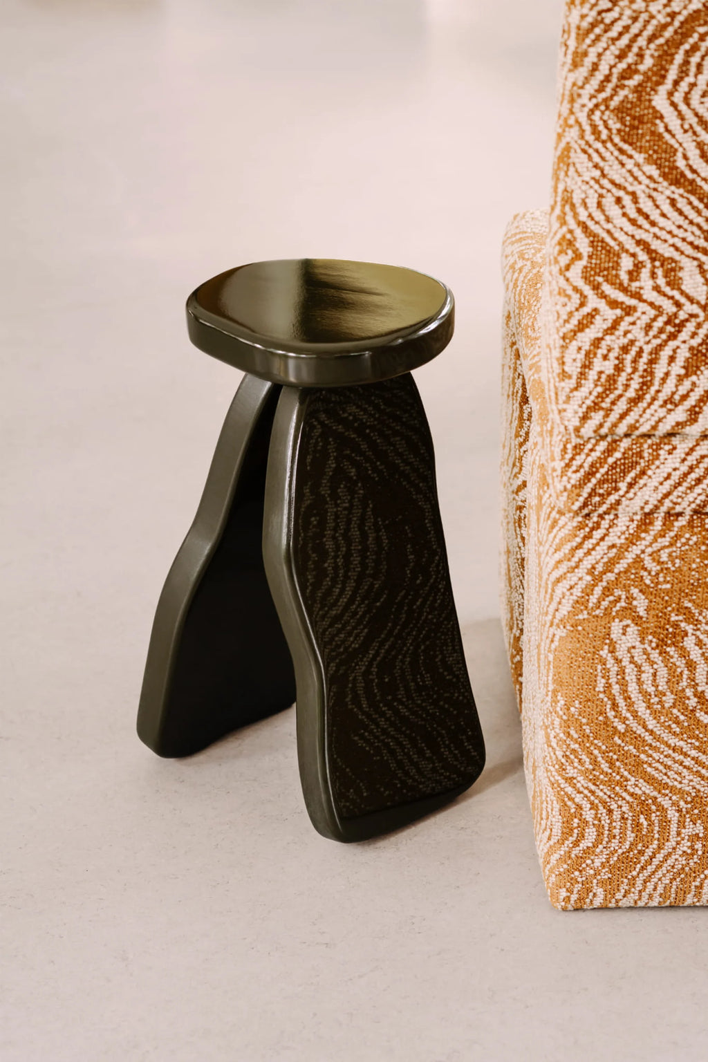 NG DESIGN Object 107 Side Table, a dark olive-green solid wood side table, featuring two curved, ridged legs, and a smooth, glossy top, styled next to a textured mustard yellow accent chair. This unique, premium side table is ideal for modern living spaces.