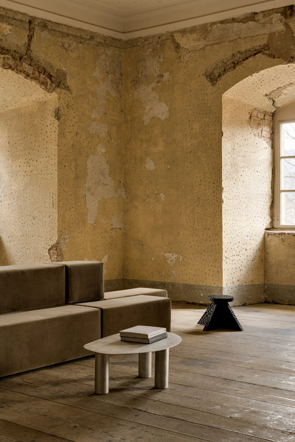 NG DESIGN Object 115 Coffee Table, a minimalist, light gray metal oval-shaped table with three cylindrical legs, displaying two stacked books. This luxury piece is perfect for a refined living space.