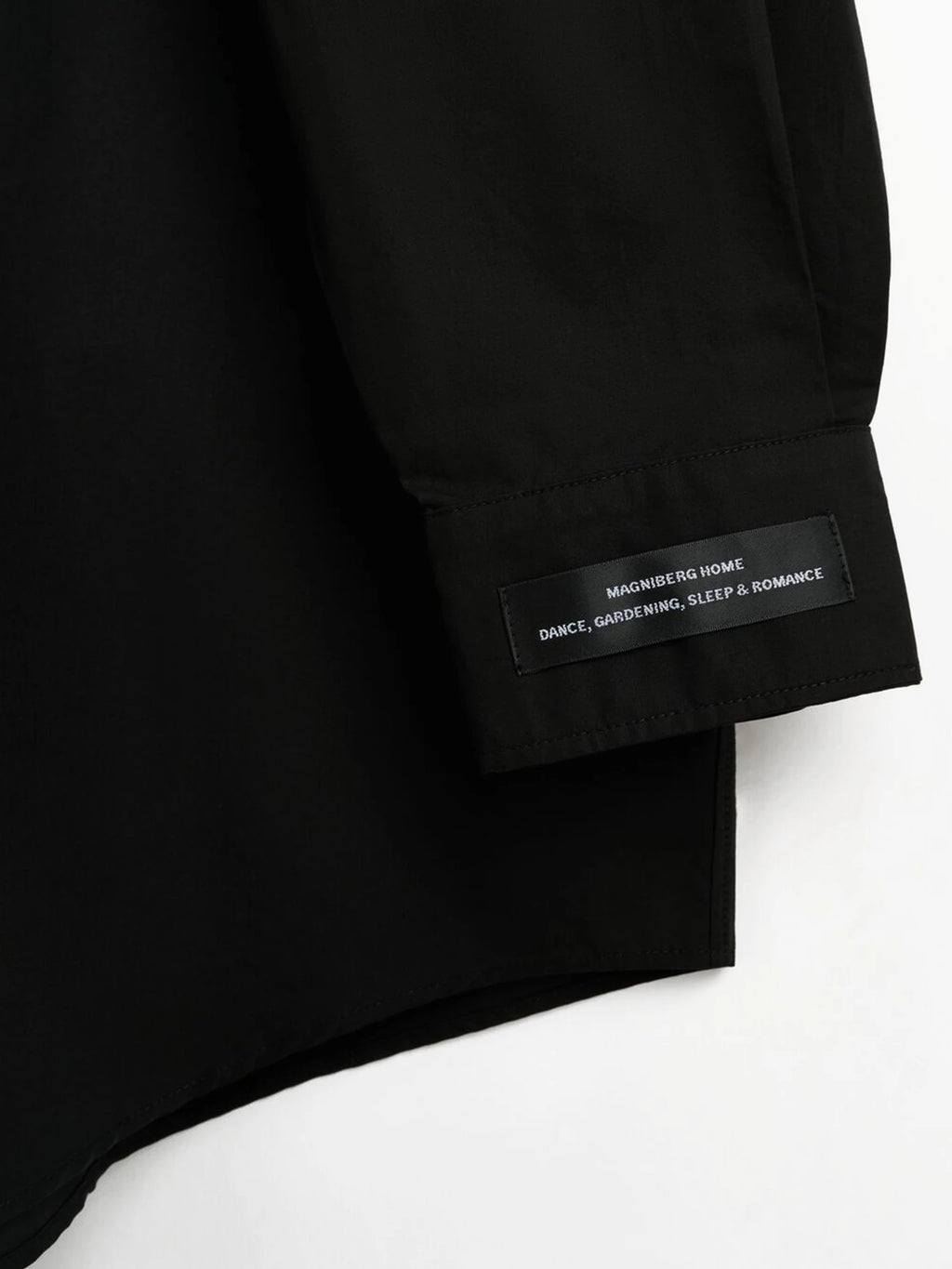 Magniberg Night shirt, a sleek black long-sleeve sleepwear piece crafted from crisp, smooth cotton fabric with a refined matte finish.