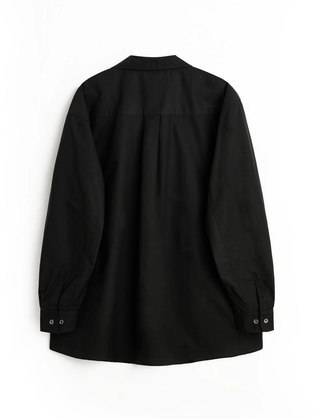 Magniberg Night shirt, a minimalist black cotton shirt with a relaxed, oversized fit, long sleeves, a classic collar, and buttoned cuffs. This smooth black poplin shirt features a curved hem and a neatly pleated back yoke, perfect for comfortable sleepwear or sophisticated loungewear.