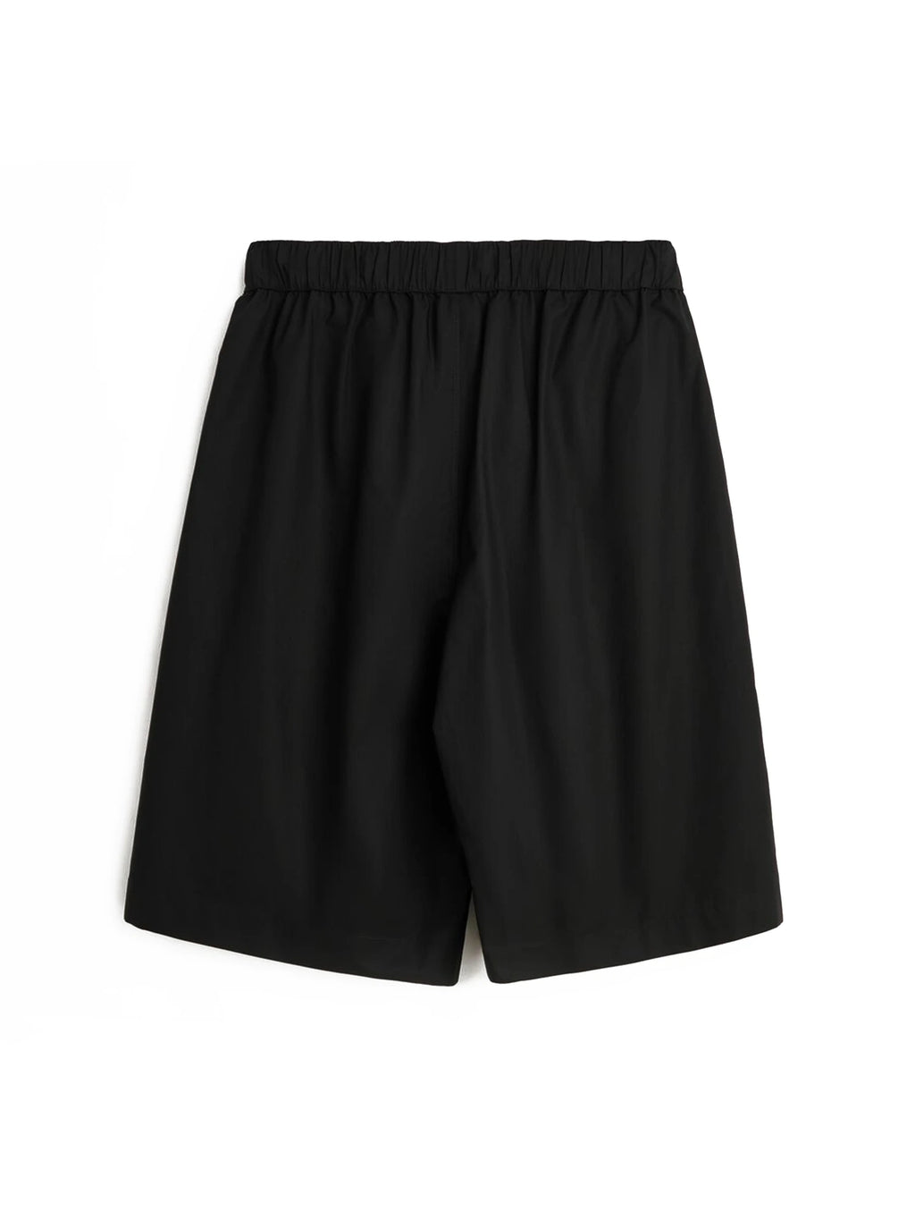 Magniberg Night shorts, a pair of minimalist black shorts featuring a relaxed, wide-leg silhouette and a comfortable elastic waistband. Crafted from a soft, smooth cotton blend fabric, these versatile shorts are ideal for comfortable home wear, casual summer outfits, or minimalist sleep styling.