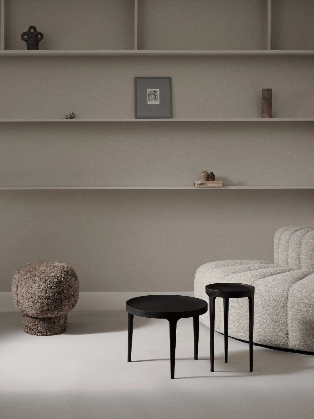 NORR11 Ghost Side Table, a modern minimalist side table crafted from solid wood with a sleek matte black finish. Its sculptural design features a round tabletop supported by three slender, tapered legs, creating an elegant and organic silhouette. Perfect as a contemporary accent table for living rooms, bedrooms, or sophisticated entryways.