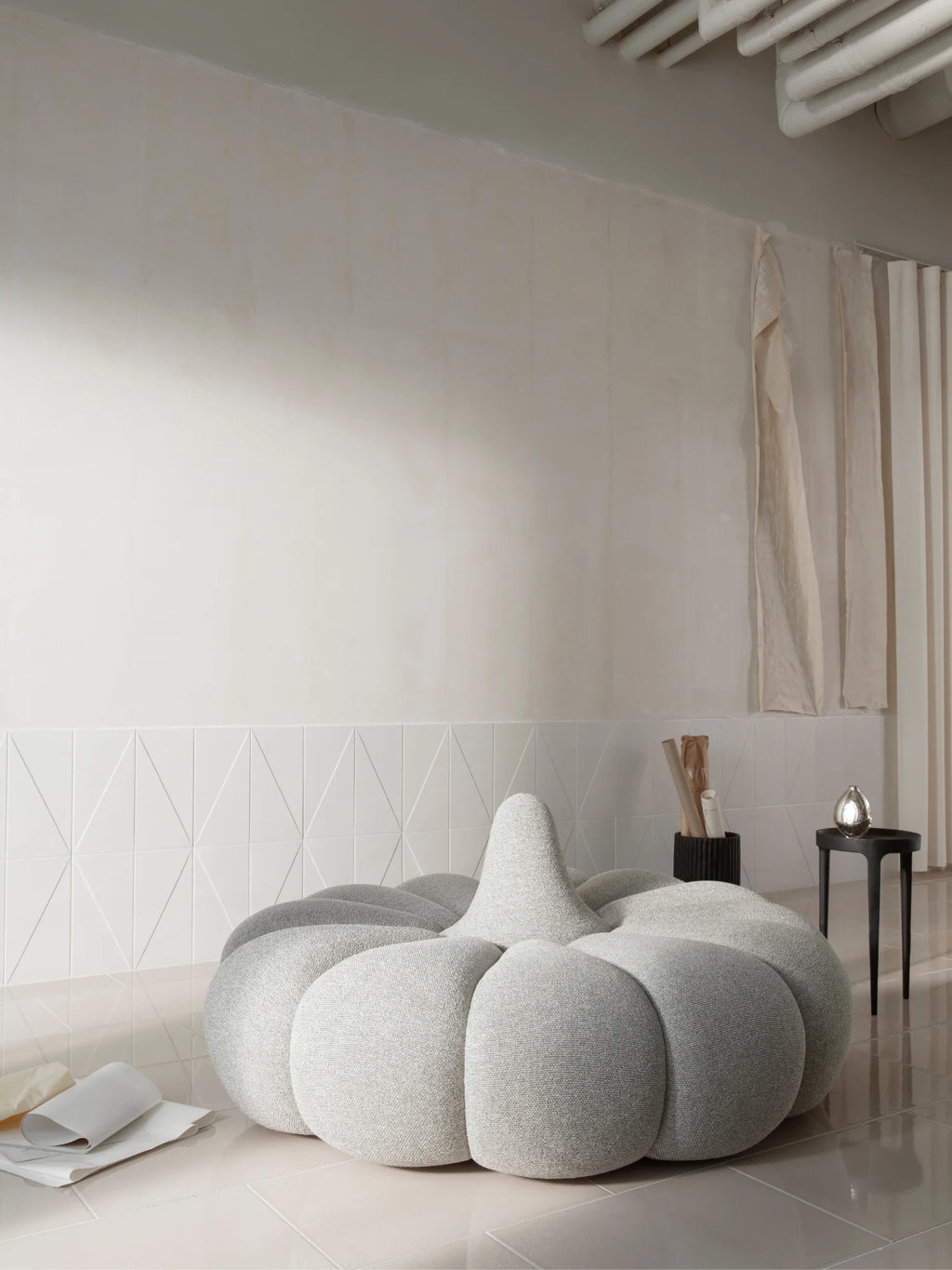 NORR11 Ghost Side Table, a striking matte black side table crafted from solid metal, featuring a sculptural, organic form with a substantial, irregularly shaped top and three robust, tapering legs. This modern minimalist accent table brings a sophisticated, brutalist-inspired aesthetic to contemporary living rooms, bedrooms, or entryways.