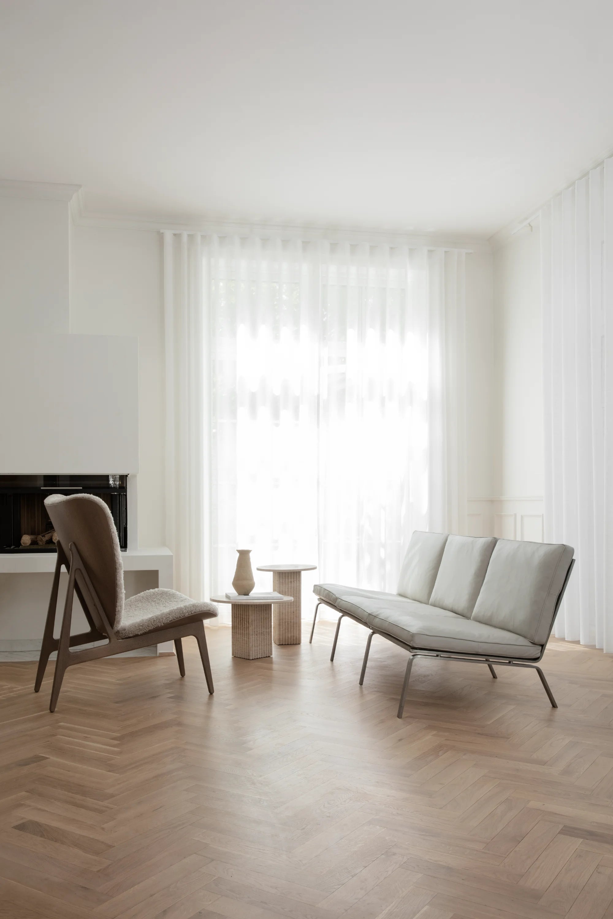 Modern living room with a gray sofa and chair on a wooden floor.