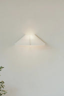  Nebra Wall Lamp mounted on a white wall, emitting warm ambient light