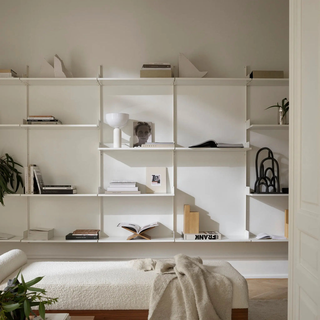 New Works Display Shelf, a sleek white modular shelving unit crafted from clean-lined metal with multiple adjustable shelves, offering a versatile wall-mounted storage solution. This modern minimalist display system is perfect for organizing books and showcasing decor in Scandinavian living rooms, contemporary home offices, or minimalist bedrooms.