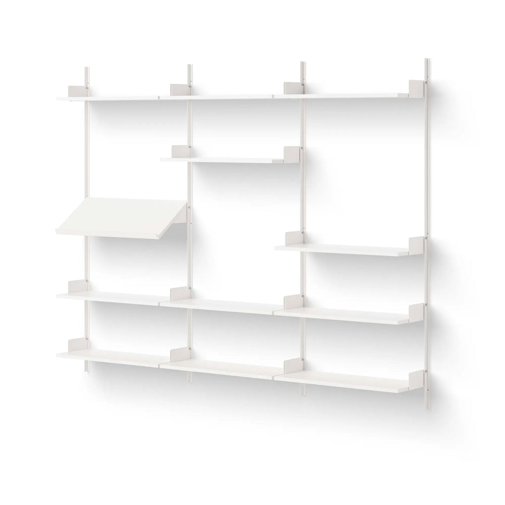New Works Display Shelf, a modern minimalist wall-mounted shelving unit crafted from thin white powder-coated steel with a sleek, modular design. This contemporary storage system features multiple horizontal shelves and an angled display shelf, supported by clean vertical rails and subtle L-shaped brackets. Ideal for Scandinavian living rooms, home offices, or bedrooms seeking versatile and elegant wall shelving for books and decor.
