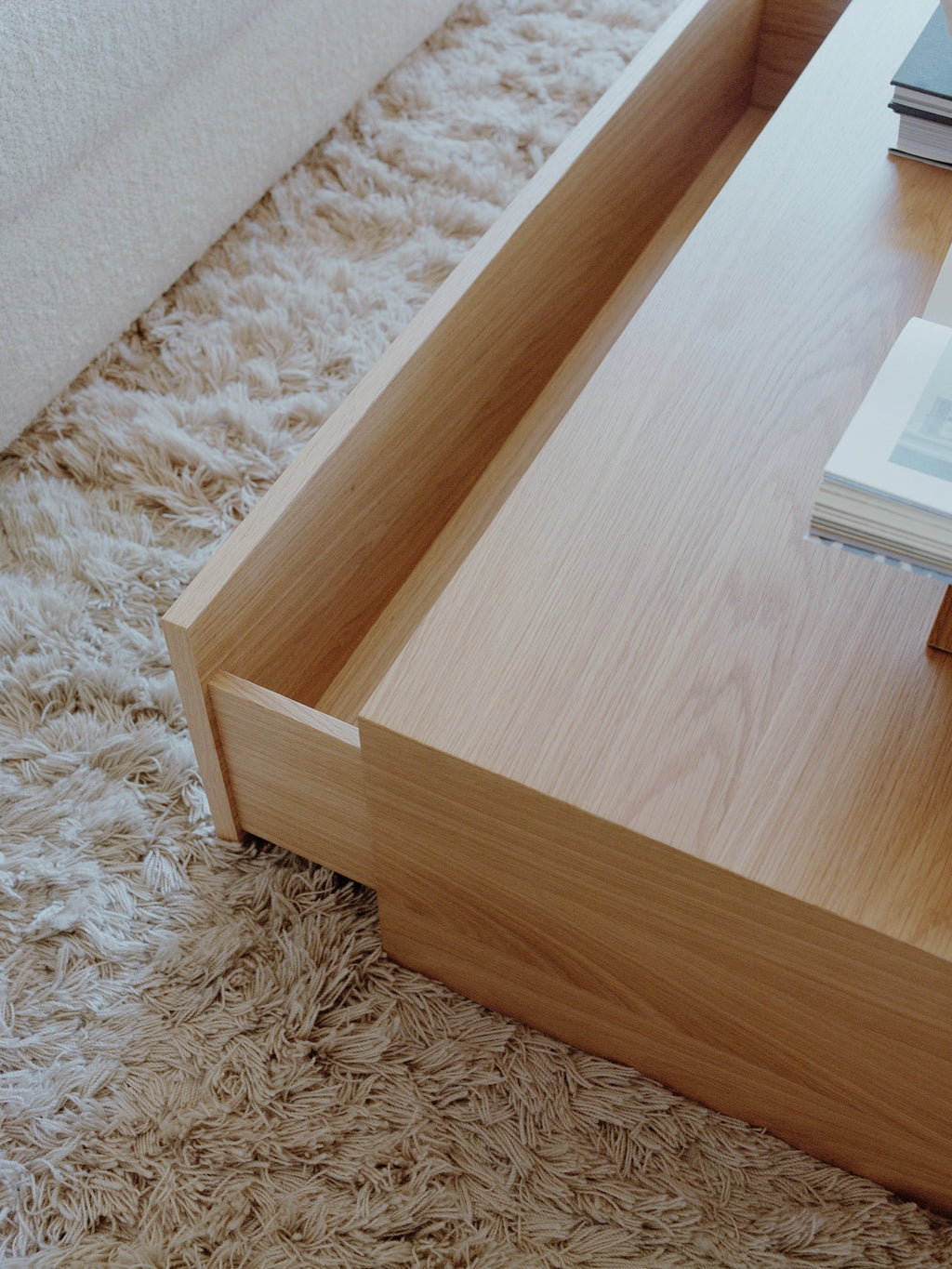 New Works Mass Coffee Table w. Drawer, a modern minimalist coffee table crafted from light natural oak wood, featuring clean rectangular lines and an integrated open storage compartment. This contemporary solid oak coffee table offers functional design and a warm aesthetic, ideal for Scandinavian living rooms and organic modern interiors.